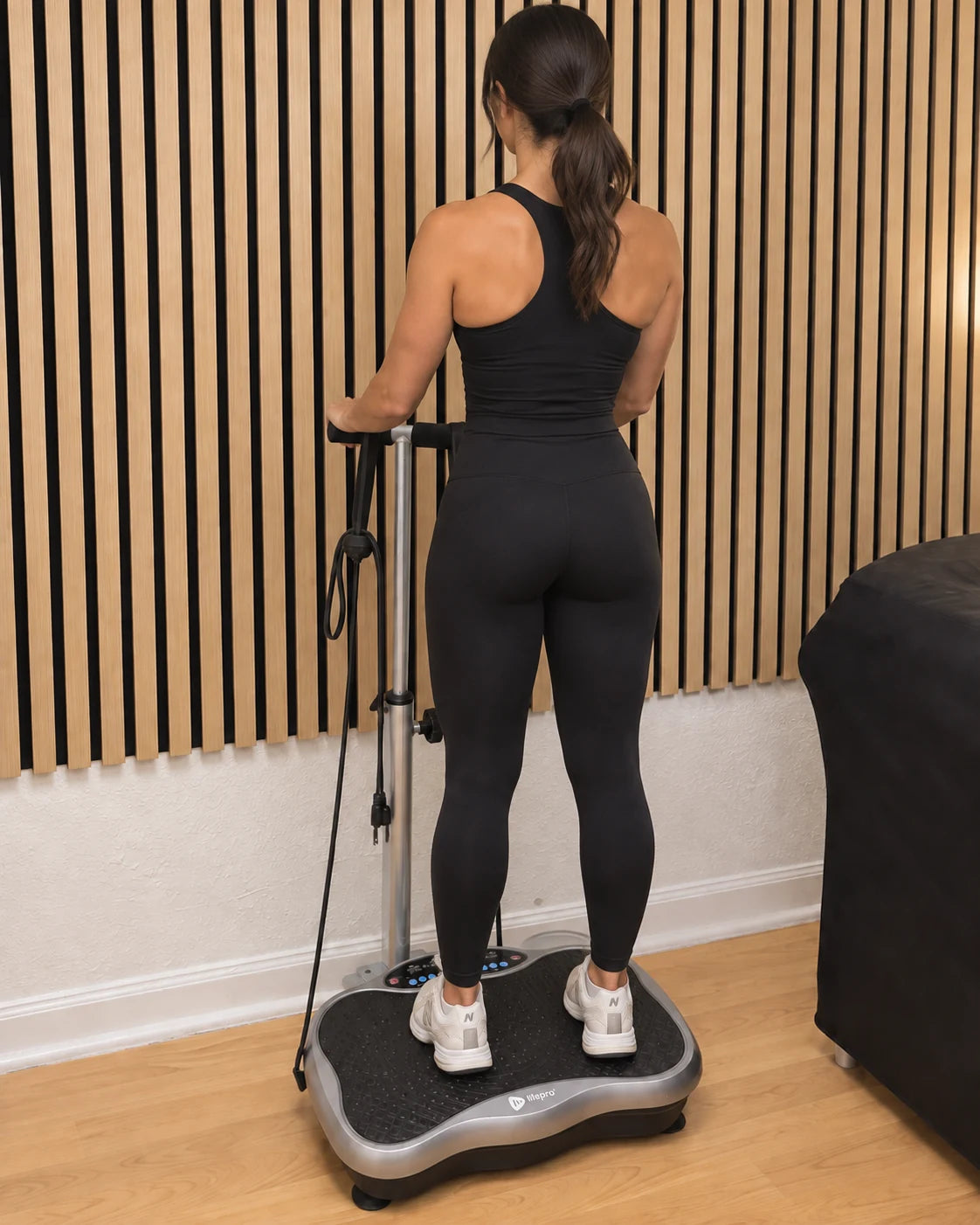 Illustrative scene of a woman facing the wall while using the vibration plate in our studio